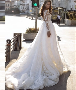 Exquisite detail of bridal gown featuring long lace sleeves and a deep V-neck back design