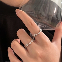 Close-up of silver leaf-shaped ring with pave zircon stones on a model's hand