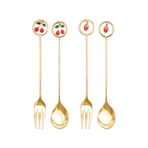 Close-up of golden stainless steel dessert forks and spoons with cherry fruit pendants