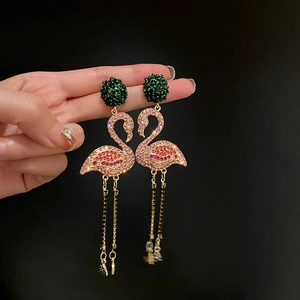 Detail of flamingo tassel earrings with pink rhinestones and green crystal studs