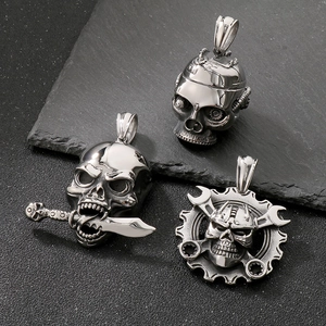 Three punk style silver skull pendants with mechanical gear and pirate motifs on stone