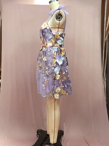 Gros plan détaillé des broderies florales 3D sur une robe moulante en tulle violet