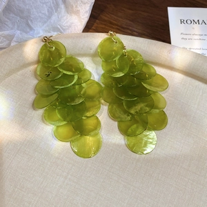 Detail of green shell petal tassel earrings with a cascading multi-layer grape design