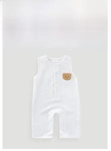 Detail of baby cotton romper with a plush bear patch and breathable gauze texture