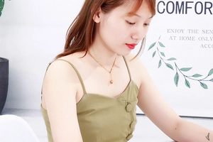 Close-up of a delicate gold heart pendant necklace on a model's collarbone