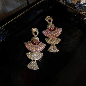 Detailed view of luxury fan-shaped earrings with colorful zircon stones on a dark base