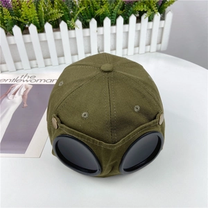 Detail of army green pilot baseball cap featuring integrated black goggles and canvas fabric