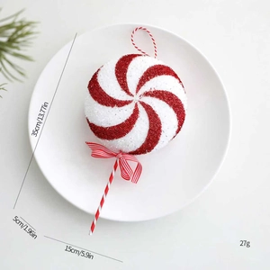 Macro shot of red and white spiral lollipop Christmas ornament with glitter texture and bow