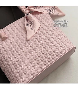 Macro shot of pink woven leather bucket bag with decorative bamboo leaf pattern silk scarf
