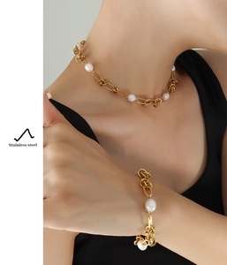 Close-up of model wearing gold stainless steel twist chain and freshwater pearl jewelry set