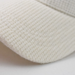 Macro shot of ivory waffle knit texture and stitching on the minimalist baseball cap brim
