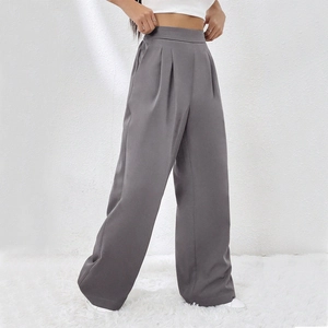 Dettaglio dei pantaloni a gamba larga grigio scuro a vita alta con eleganti pieghe