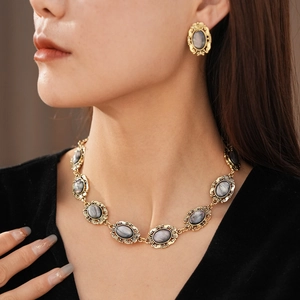 Detail of vintage gold-tone oval resin jewelry set worn by a model in elegant pose