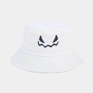 Close-up of black monster facial embroidery on a white cotton canvas bucket hat