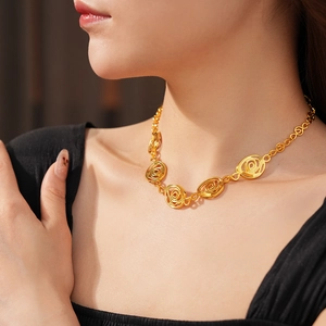 Close-up of vintage golden swirl pendant necklace showing intricate metallic texture