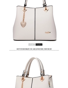 Close-up of cream tote bag featuring rose gold hardware and patterned heart charm