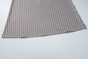 Vue détaillée du motif à carreaux marron avec des coutures soignées sur l'ourlet de robe