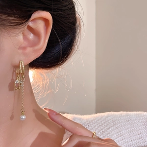 Elegant gold tulip earrings with white pearl and long tassel chains on a model