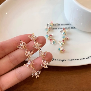 Macro detail of cascading colorful zircon butterfly earrings with elegant gold plating