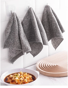 Hanging gray bamboo charcoal fiber kitchen cloths on white tile wall with soft lighting