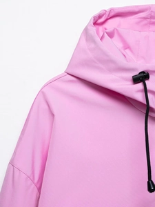 Detail of pink hooded jacket showing neckline, hood drawstrings, and windproof fabric