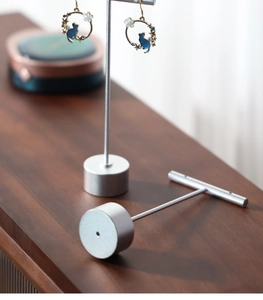 Detail view of T-shaped silver metal earring display stand with stable round base