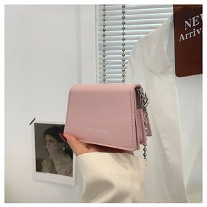 Detailed macro of pink PU leather flap bag with silver chain and FASHION & BAGS text