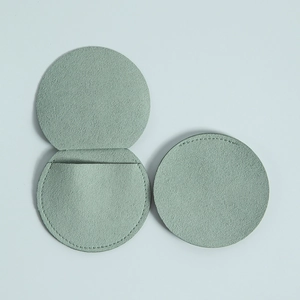 Detail view of round microfiber jewelry pouch in sage green showing inner pocket structure