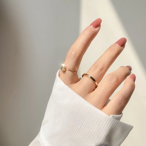 Detail of gold-plated stacking rings with pear-cut stone and square diamond accents