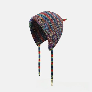 Close-up of rainbow striped knit earflap hat with colorful boho braided straps detail