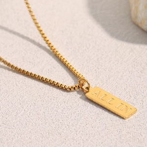 Close-up of 18K gold plated square pendant necklace with engraved ALL IN lettering