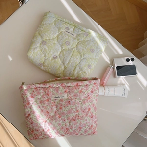 Close-up of quilted floral cosmetic bags in pink and yellow-green cotton fabric