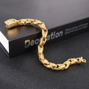 Macro shot of 10mm gold stainless steel curb link bracelet on a black book prop