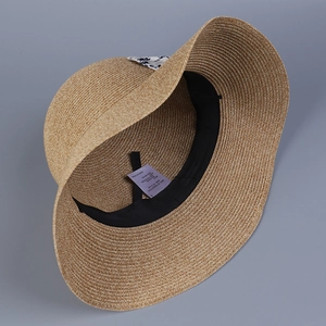 Internal detail of a brown straw hat showing sweatband and 57.5cm size label
