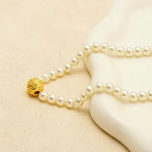 Elegant 18K gold-plated pearl necklace with a central woven textured lucky bead charm