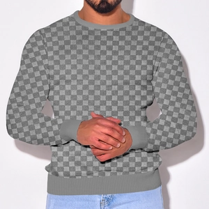 Front view of male model wearing a grey checkered knit sweater with a round neck and heavy jacquard