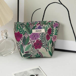 Close-up of floral embroidered cosmetic bag with purple flowers and woven brand label