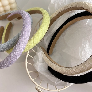 Close-up of multicolored lace crochet headbands with soft lining in a white basket