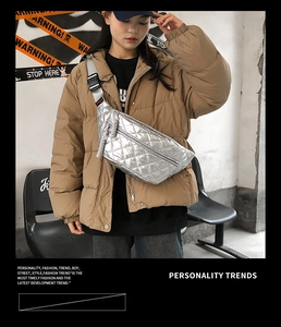 Detail of silver quilted waist bag with adjustable black strap worn across the chest