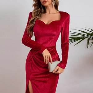 Detailed view of red velvet evening dress featuring side slit and pleated waist design