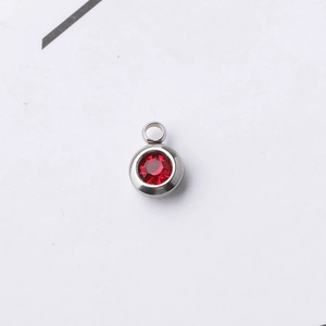 Close-up of a 6.5mm silver stainless steel pendant with a round red birthstone crystal