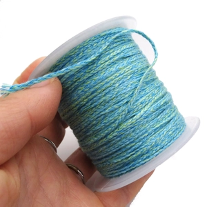 Detail showing blue and green braided cord on a spool for DIY jewelry making