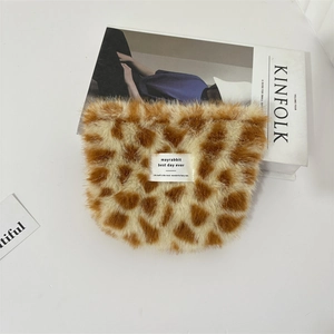 Detail of plush leopard print makeup bag with animal spots and white textile label
