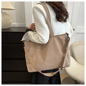 Detail of khaki corduroy tote bag showing textured fabric and adjustable wide shoulder strap
