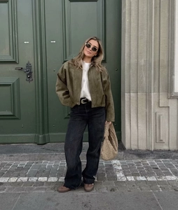 Close-up of army green faux suede jacket paired with black wide-leg washed denim jeans