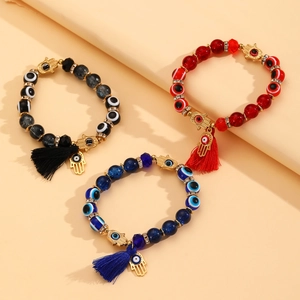 Detailopname van kralenarmbanden met boze oog, Hamsa-handhangers en zijden kwastjes