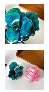 Close-up of pink and teal 3D acetate rose hair claws showing petal texture and spring mechanism