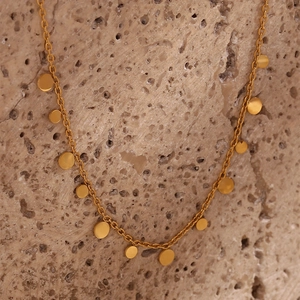 Detailed view of gold plated stainless steel necklace with small round charms on stone