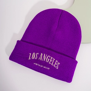 Détail macro de la broderie vintage Los Angeles sur un bonnet en tricot violet foncé