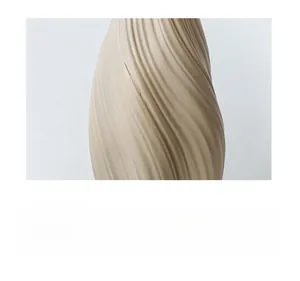 Vue macro d'un vase en céramique beige sable avec textures ondulées verticales
